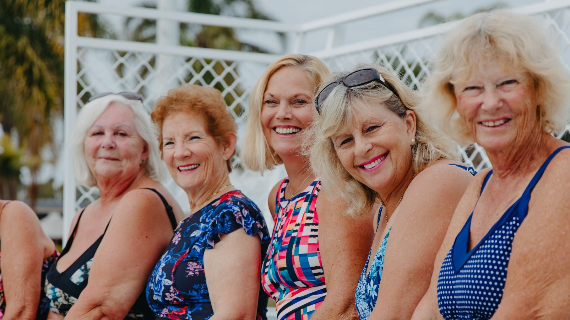 6 women pose together wearing various styles of swimwear
