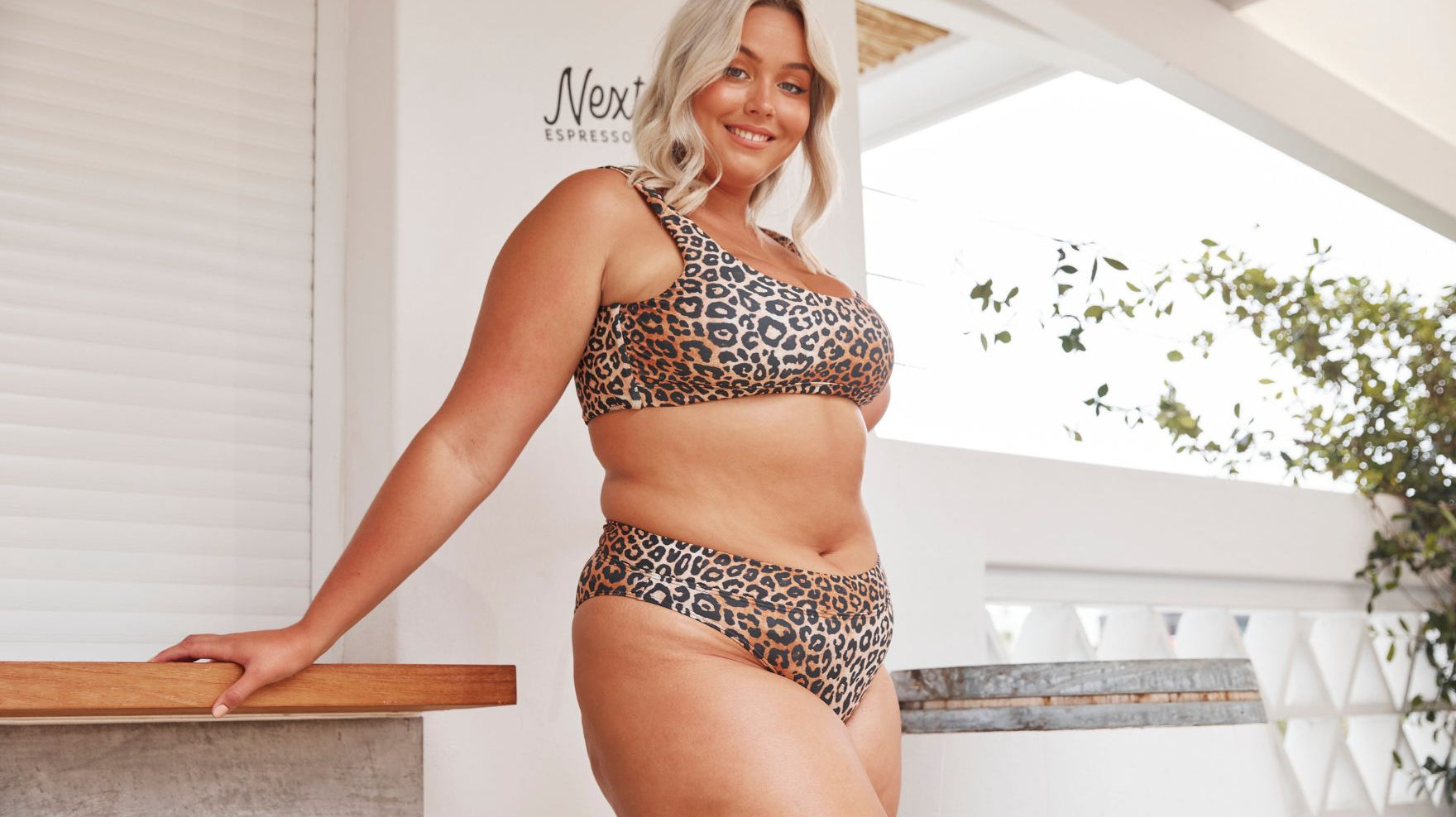 woman with blonde hair wears leopard bikini with high cut pant
