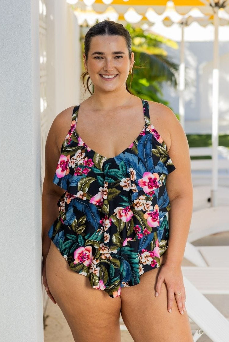 A woman wearing a floral tiered tankini swimsuit outdoors.