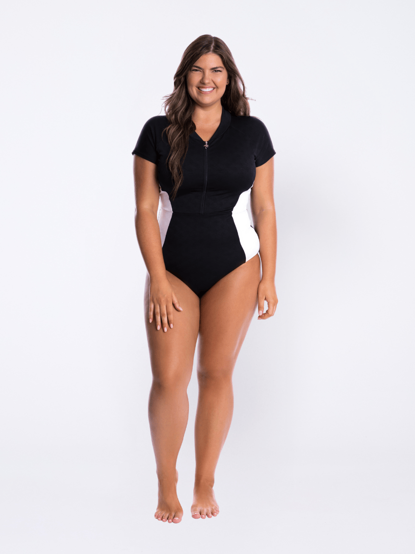 Model in studio wearing a cap sleeve one piece with zip detail