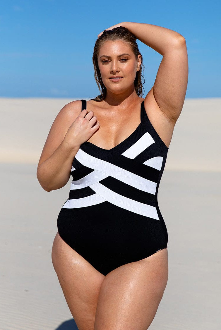 Model on beach wearing flattering criss cross texture one piece