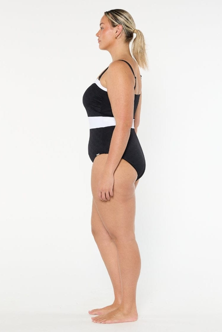 Woman wearing a black and white swimsuit on a white background