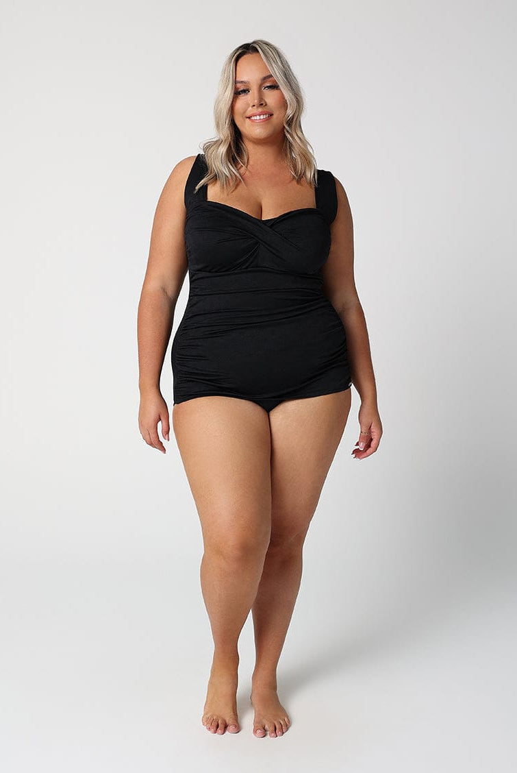 Woman wearing a black swimsuit against a white background
