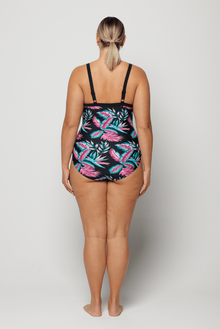 Woman wearing a colorful floral swimsuit on a white background