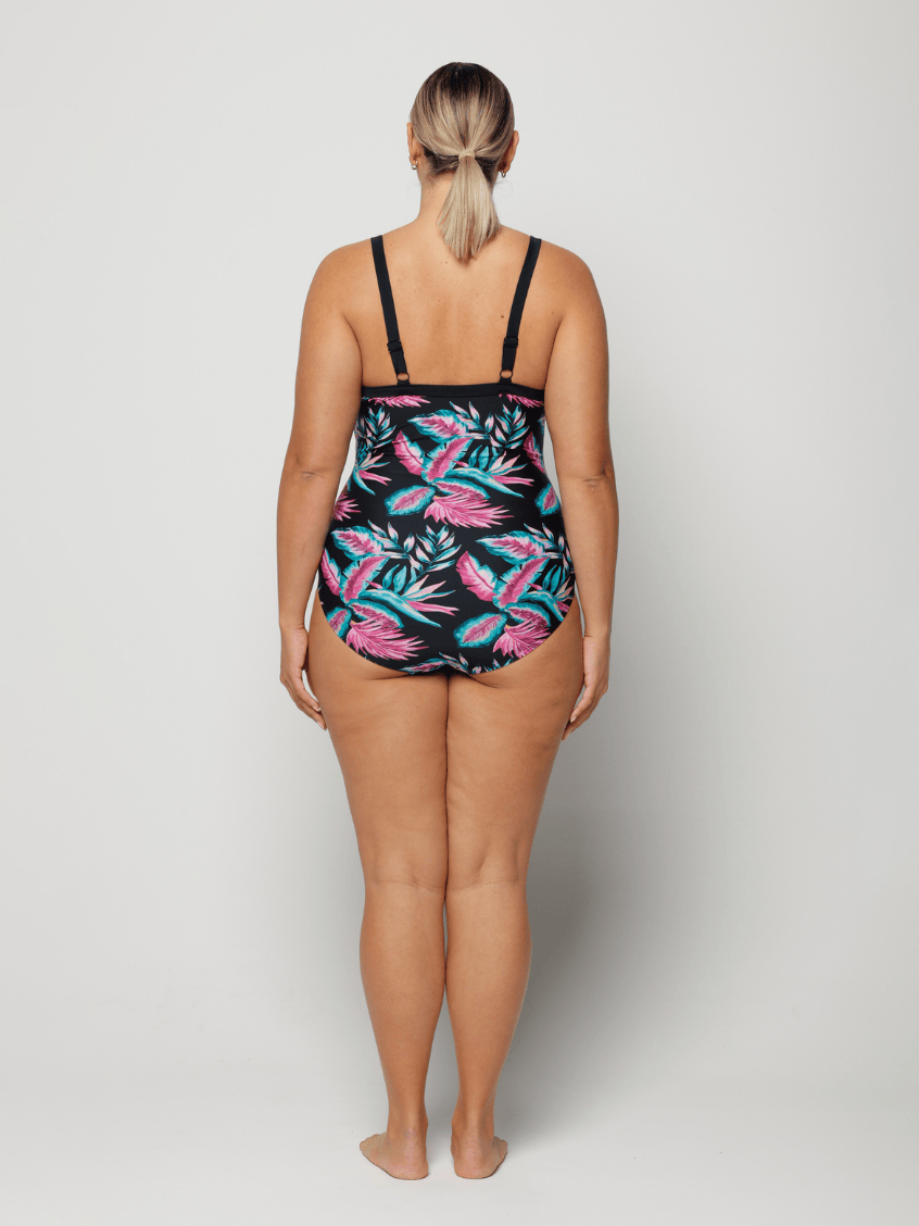 Woman wearing a colorful floral swimsuit on a white background