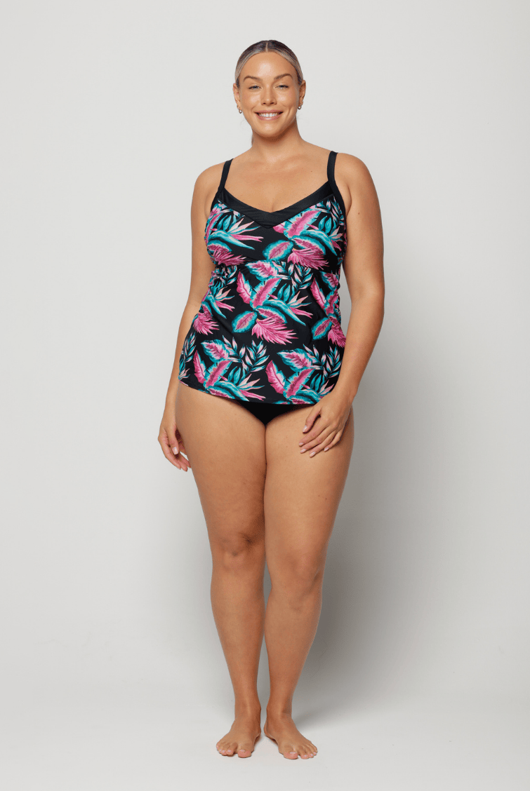 Woman wearing a black swimsuit with colorful leaf pattern on a white background