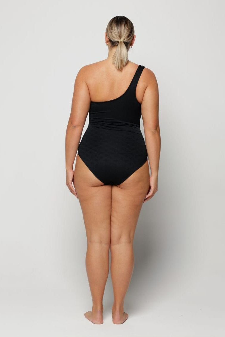 Person wearing a black swimsuit on a plain background