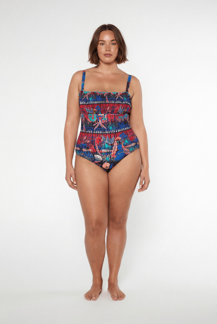 Woman wearing a colorful patterned swimsuit on a white background