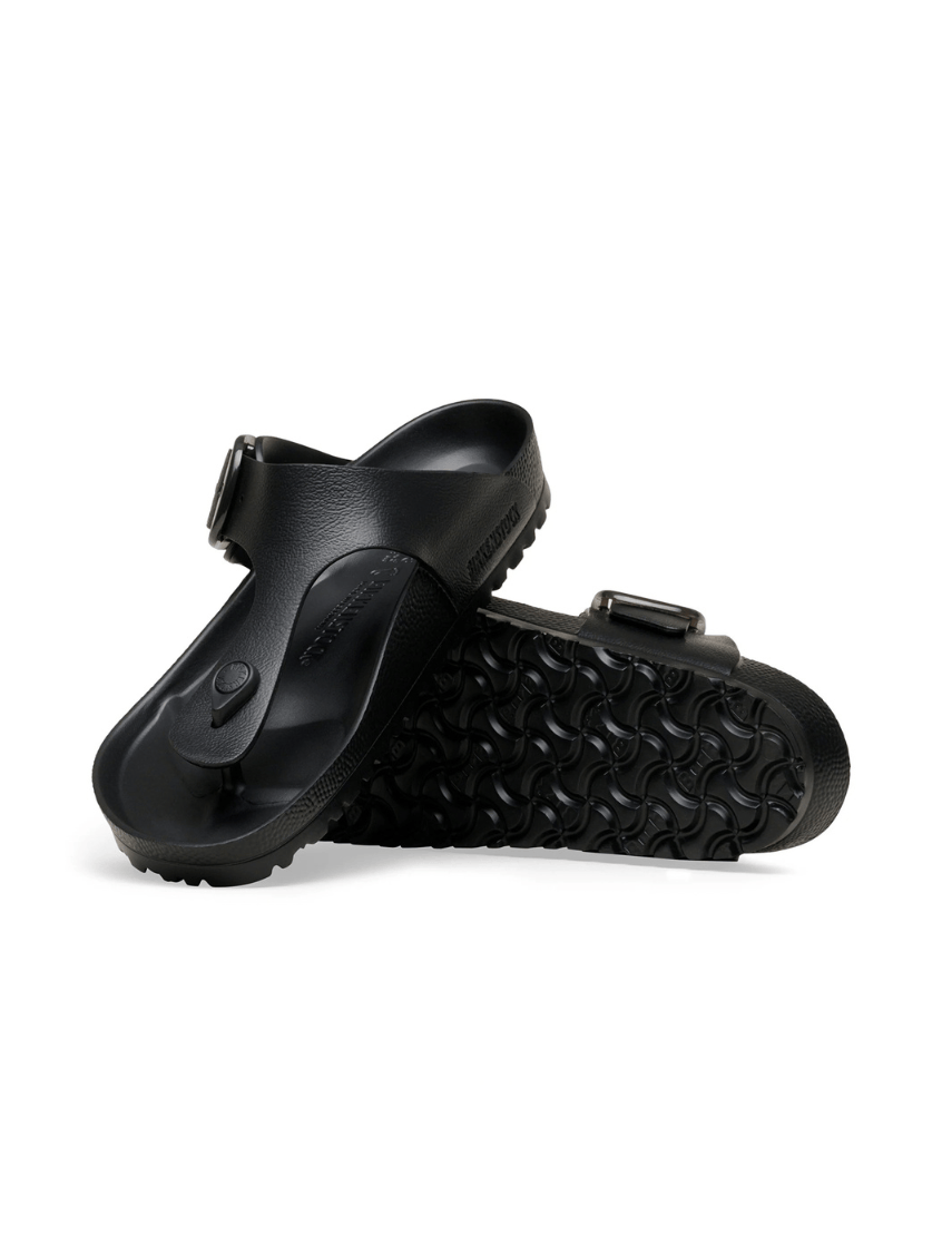 A pair of black slide sandals with adjustable straps and textured soles, shown from a side angle on a white background.