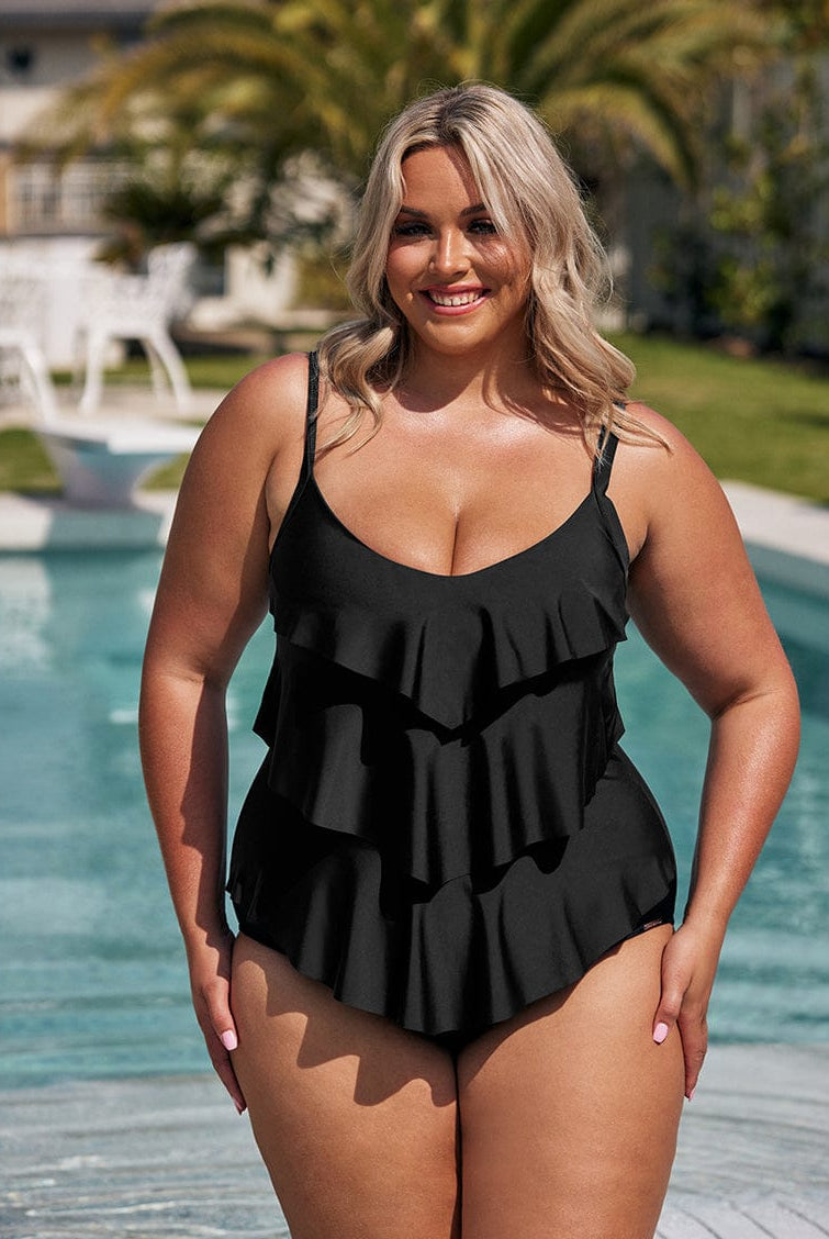 Woman wearing a black ruffled swimsuit by a pool