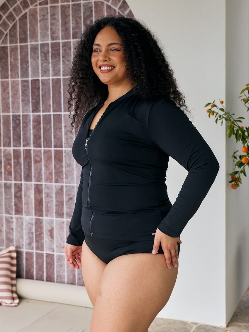 Side profile of model wearing a long sleeve rashie with full zip detail in chlorine resistant