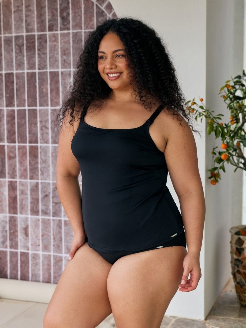 Side of model wearing a tank tankini top in black chlorine resistant with little detail on each strap