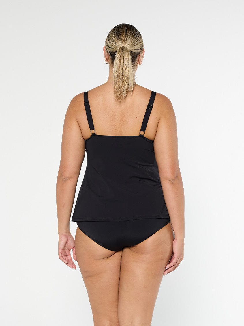 Blonde model shows the back of black pool proof tankini top with adjustable straps