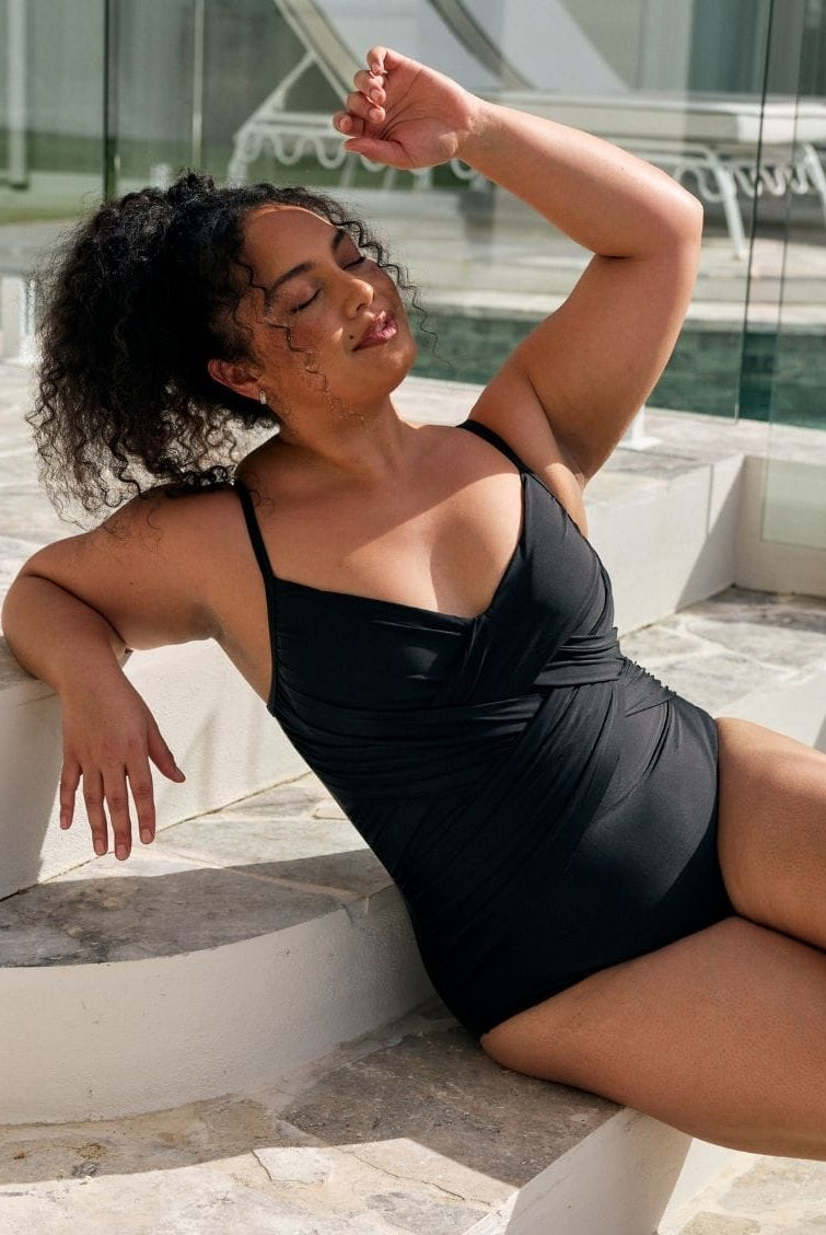 Close up detail image of model wearing a metallic black criss cross one piece in black