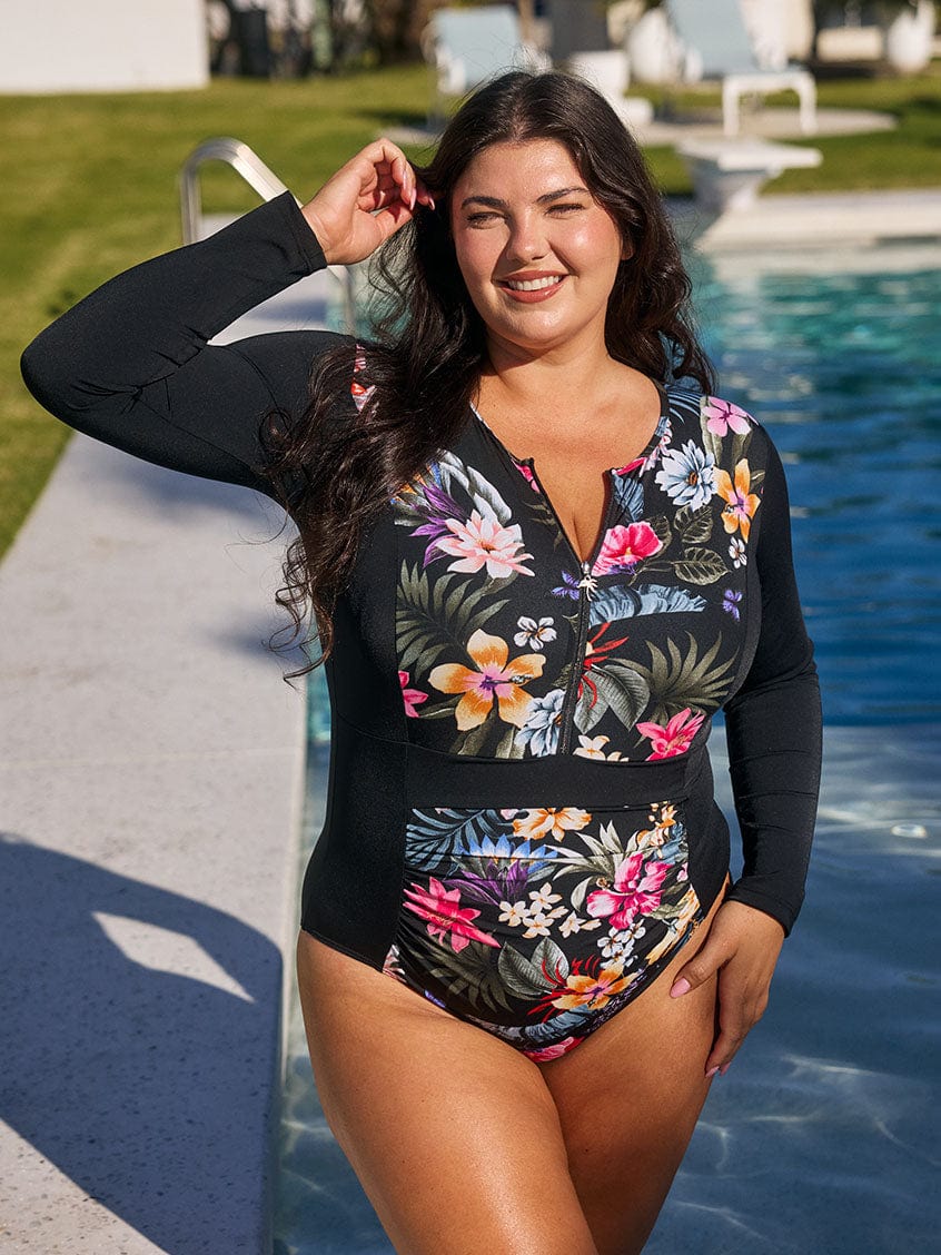 model wears chlorine resistant black floral one piece with supportive zip front and long sleeves