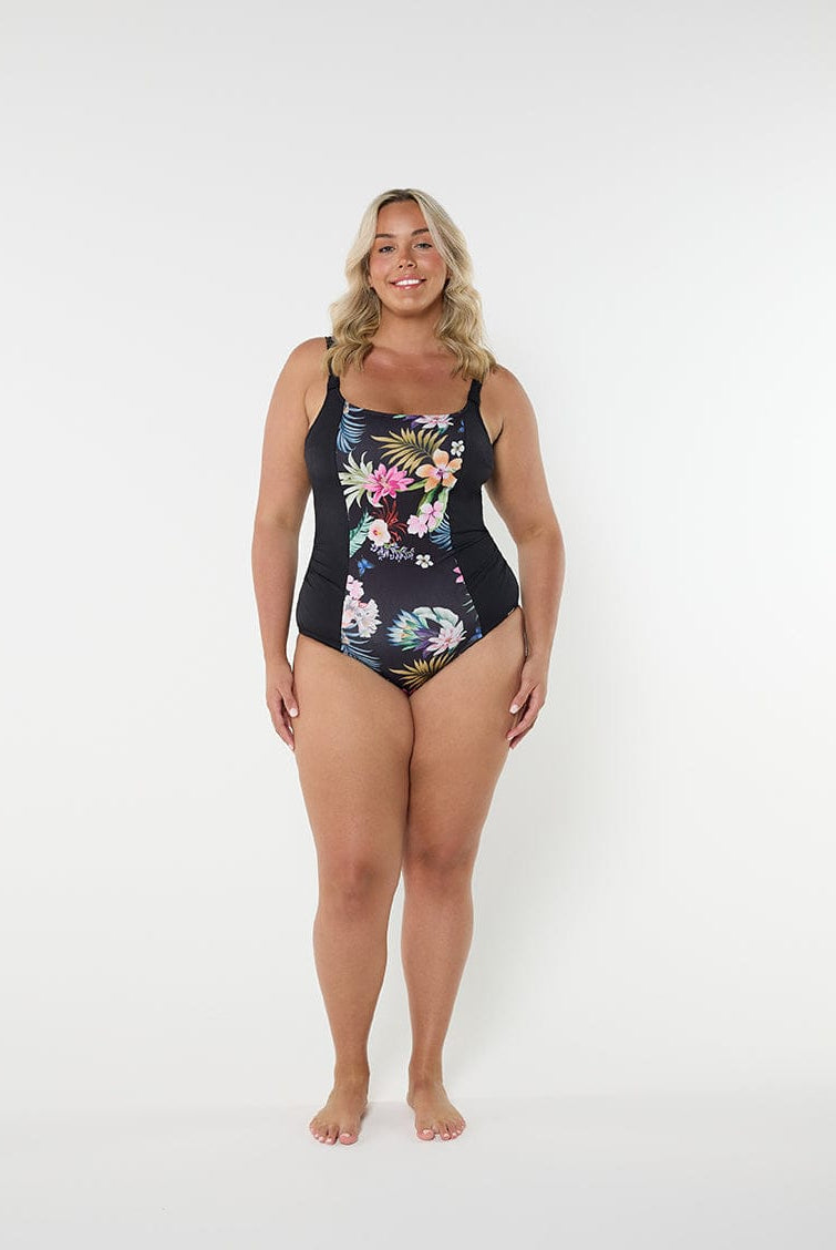 Woman wearing a floral one-piece swimsuit on a white background