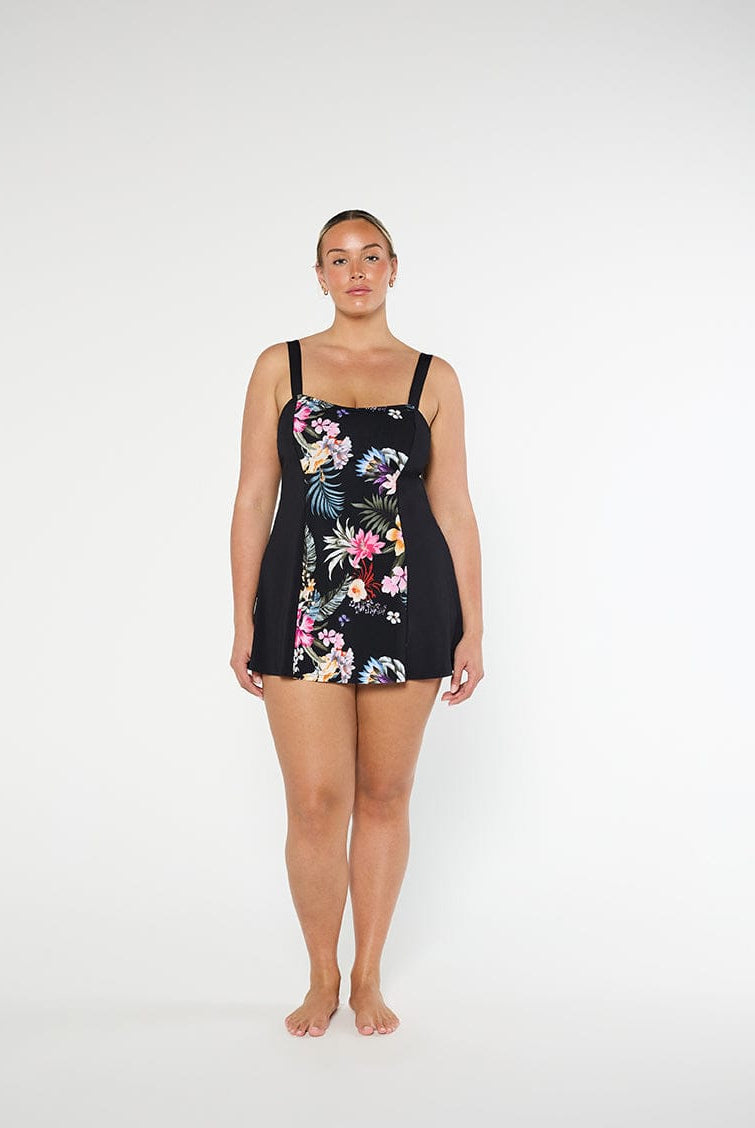 Black Floral Swimdress on model standing in front of a white wall