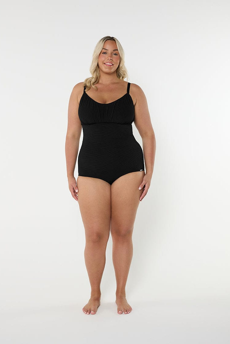 Woman wearing a black swimsuit against a white background