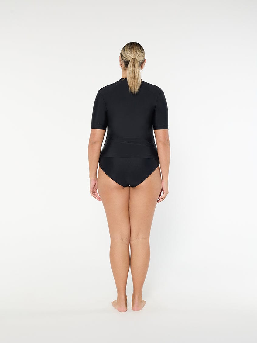 Person wearing a black swimsuit on a white background