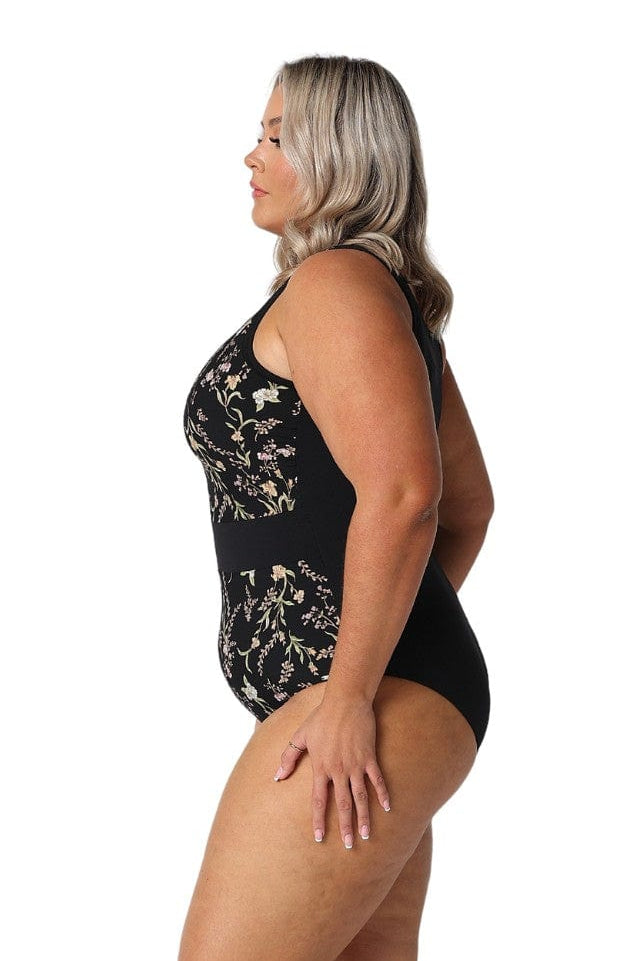 Model showing side of black floral zip up one piece