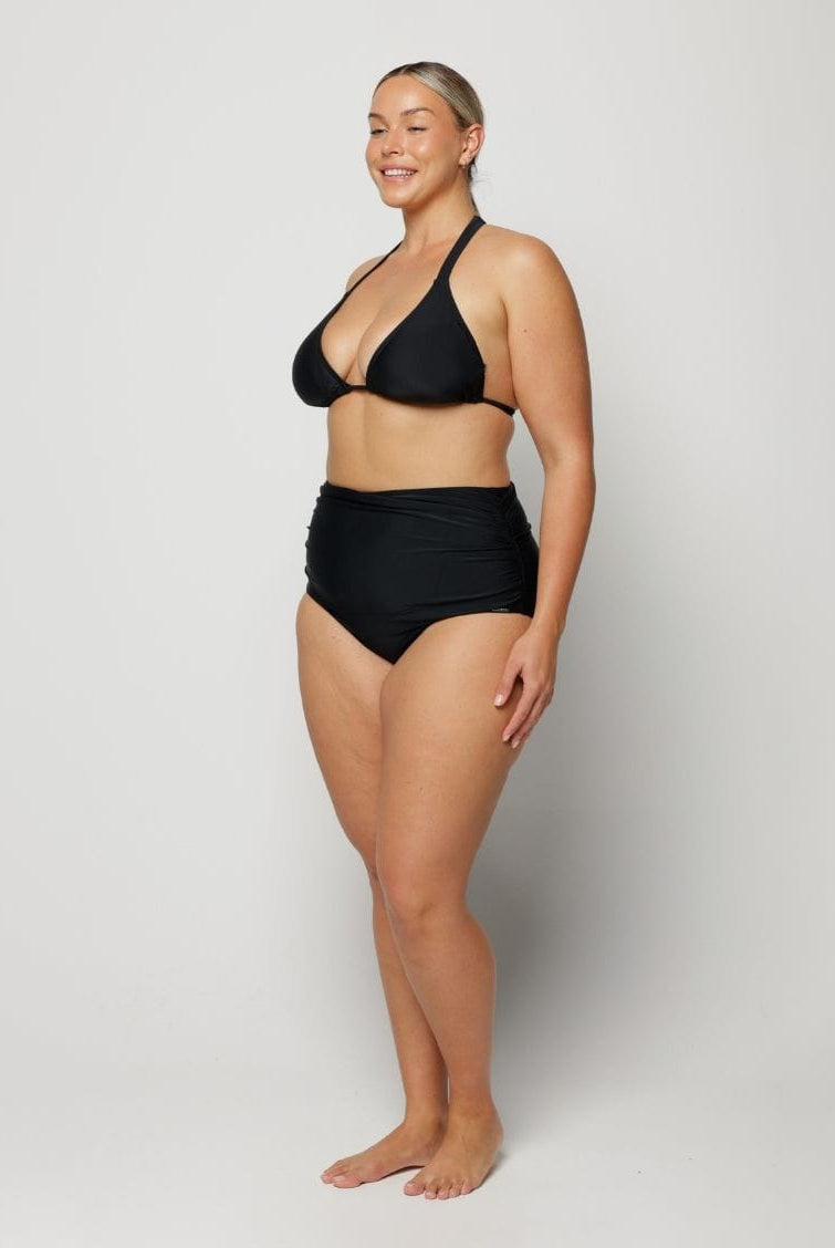 Woman wearing a black bikini against a white background