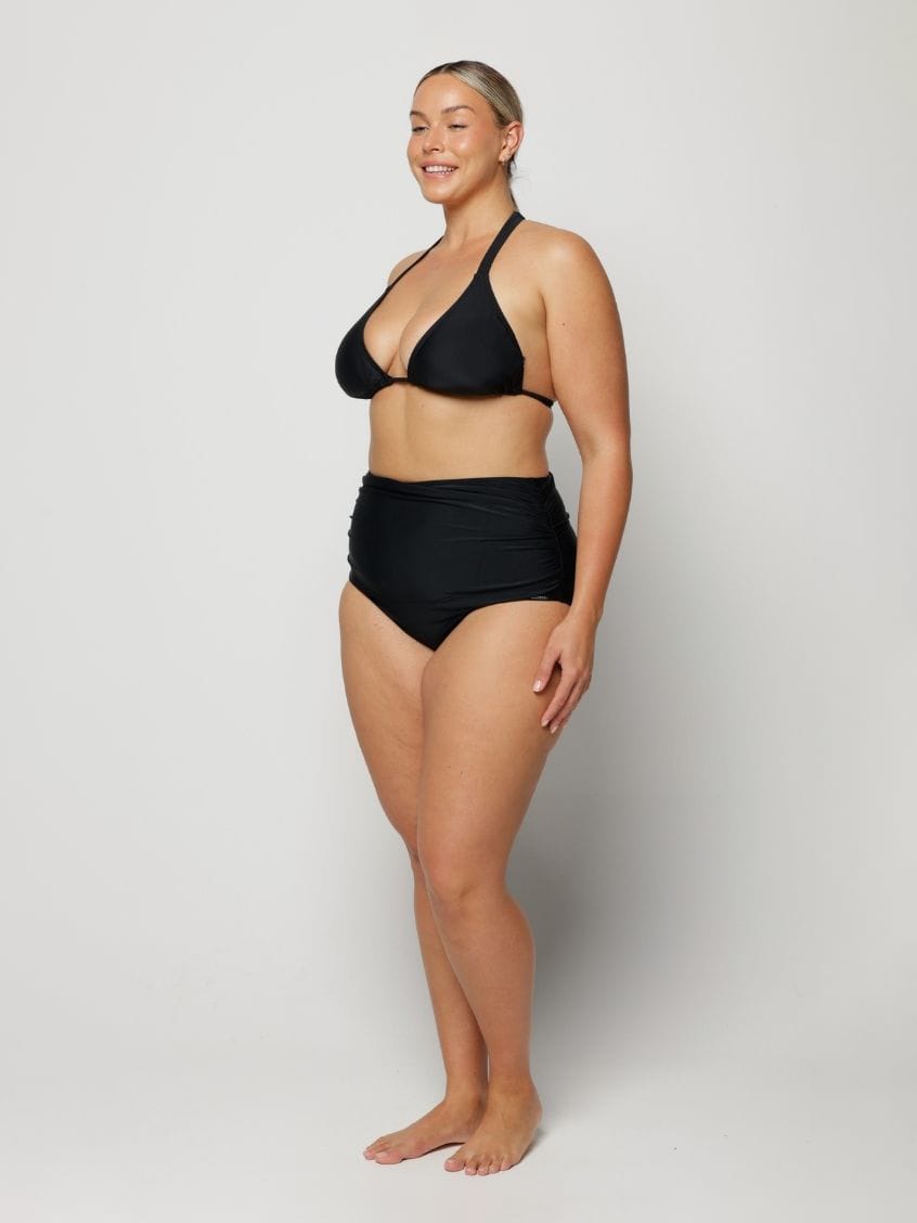 Woman wearing a black bikini against a white background