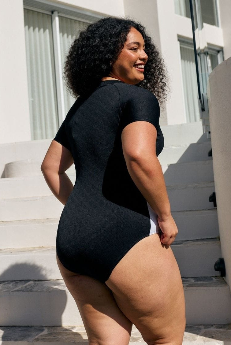 Back of model showing off model high neck one piece with textured black and white print in chlorine resistant