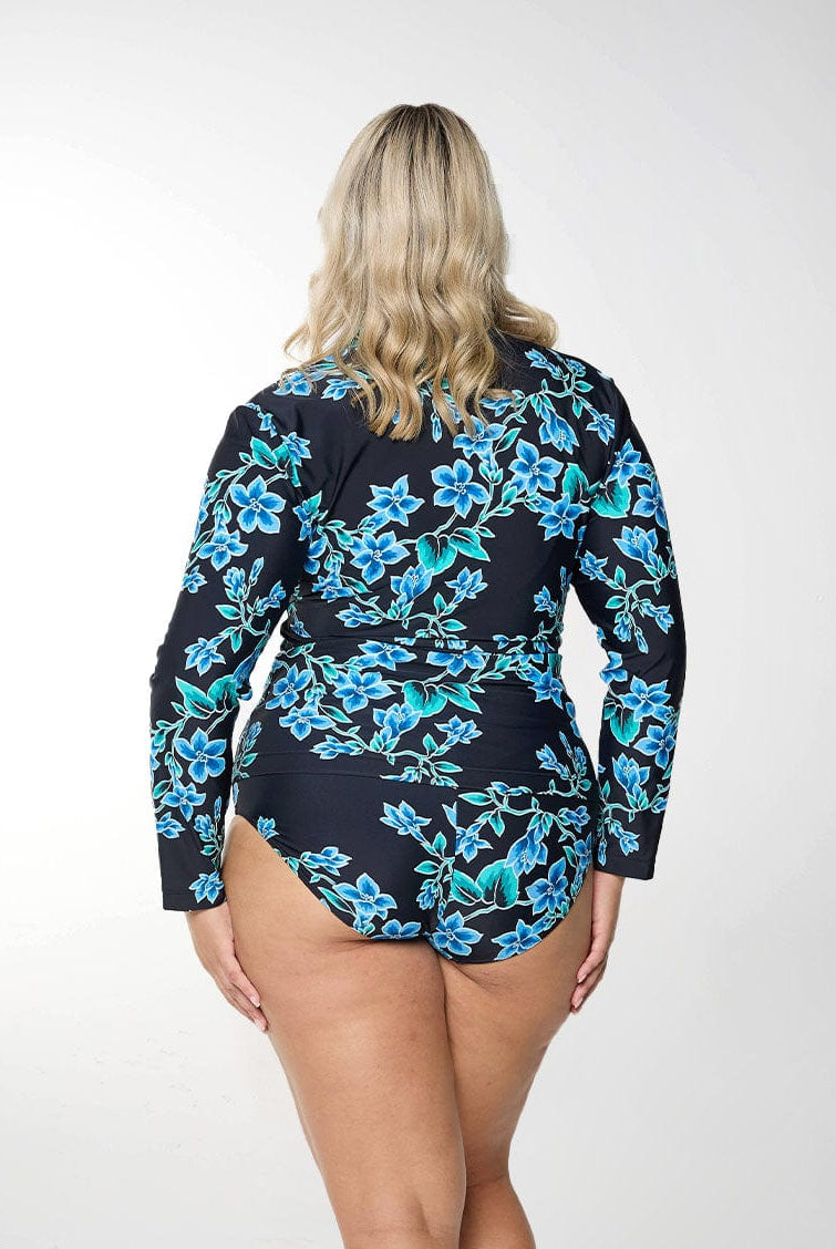 Blonde model shows back of figure-flattering blue floral rash vest with long sleeves