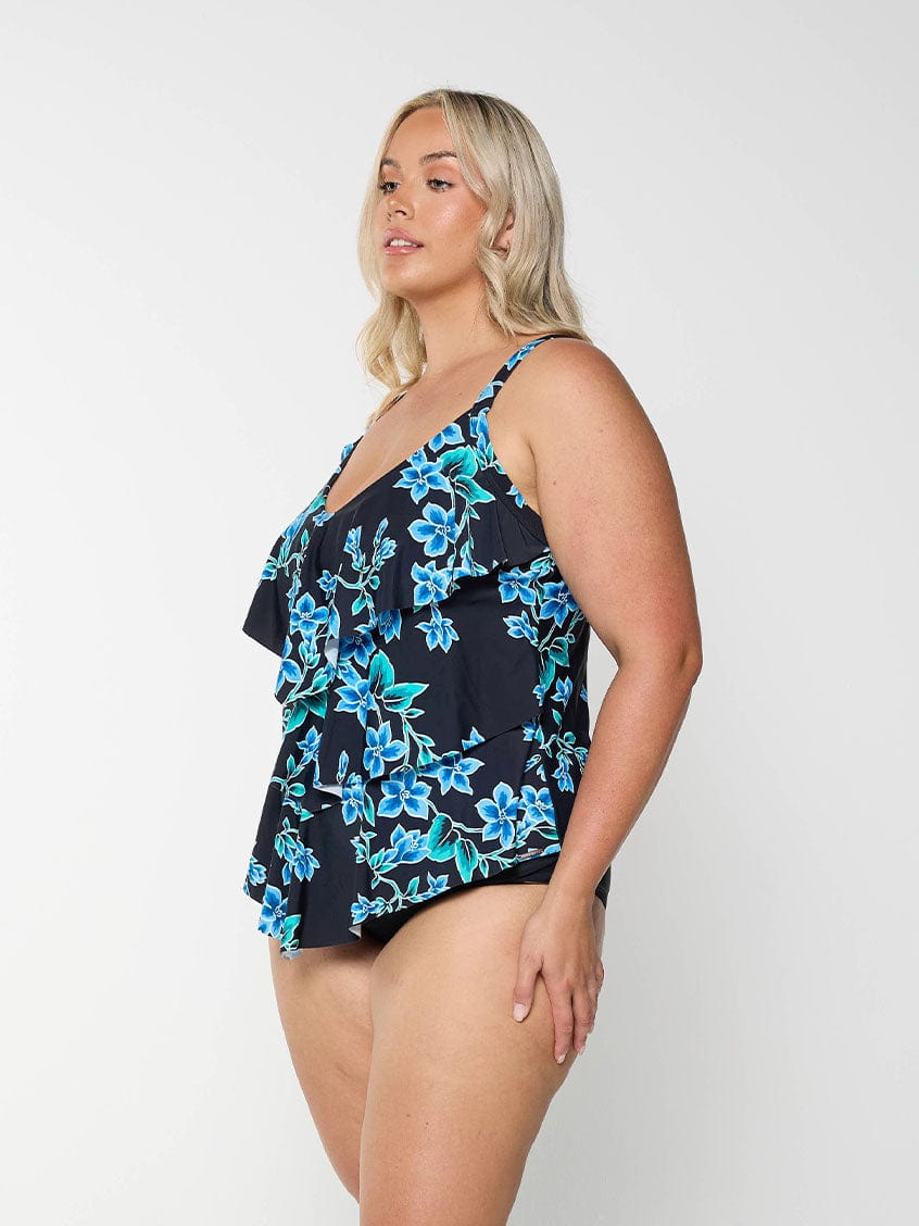 Blonde women wears figure flattering ruffle tankini top with a blue floral pattern