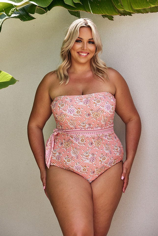Blonde model wearing blush pink floral strapless one piece