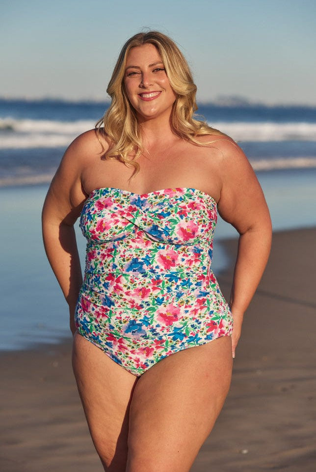 Model wearing multi-coloured floral strapless swimsuit at beach