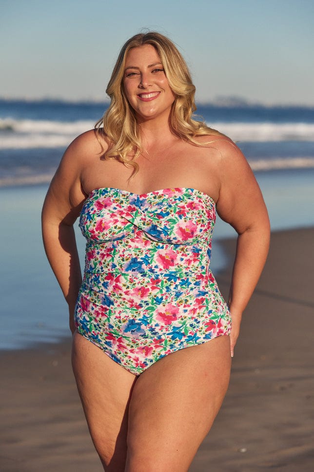 Model wearing multi-coloured floral strapless swimsuit at beach