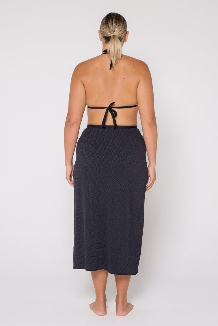 Woman wearing a black halter top and skirt on a white background