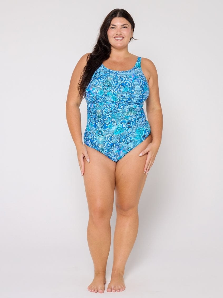 Woman wearing a blue patterned swimsuit on a white background