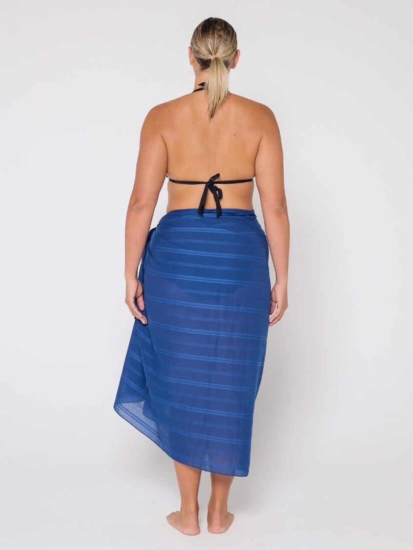 Woman wearing a blue striped sarong on a white background