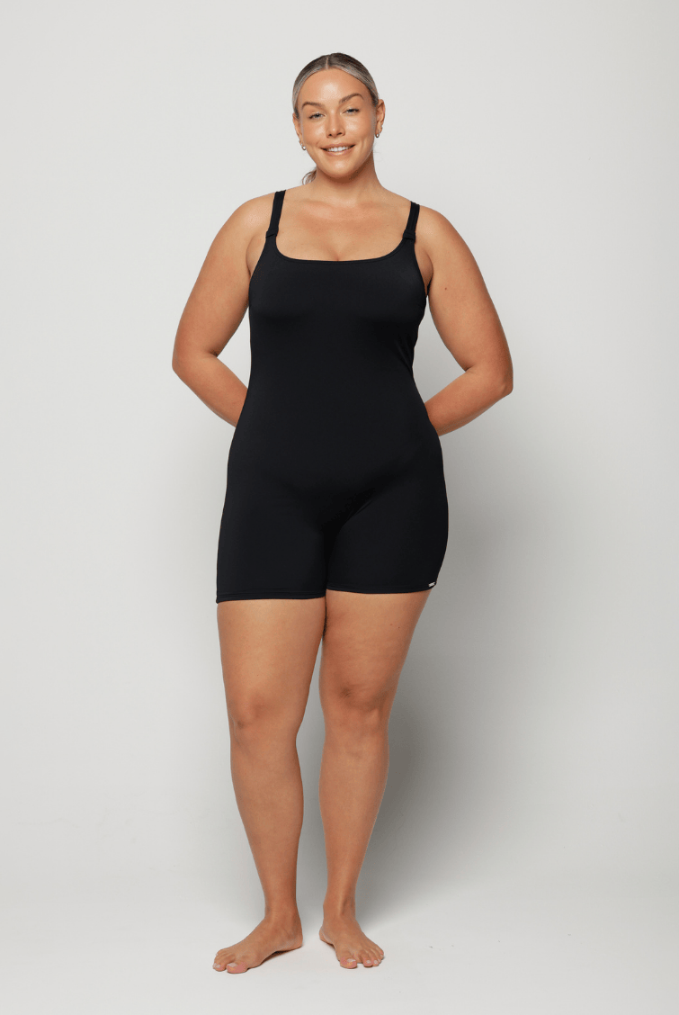 Person wearing a black chlorine resistant bodysuit against a white background
