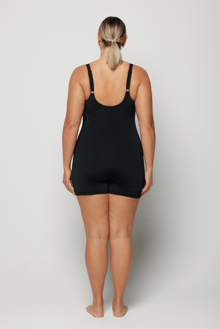 Person wearing a black chlorine resistant boyleg swimsuit on a plain background