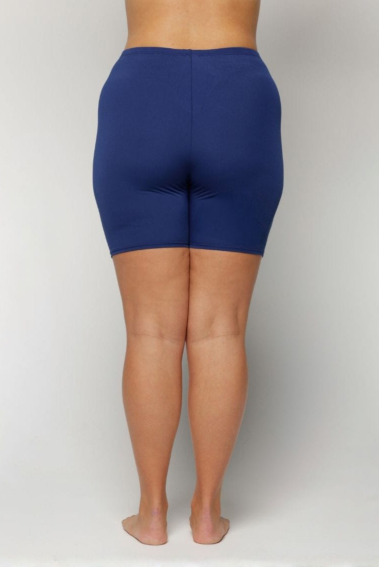 Person wearing blue shorts on a plain background with chlorine resistant fabric