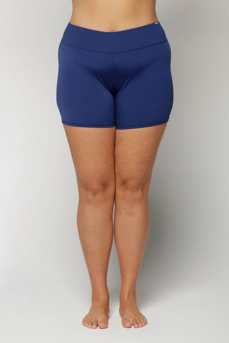 Person wearing blue swim shorts on a plain background
