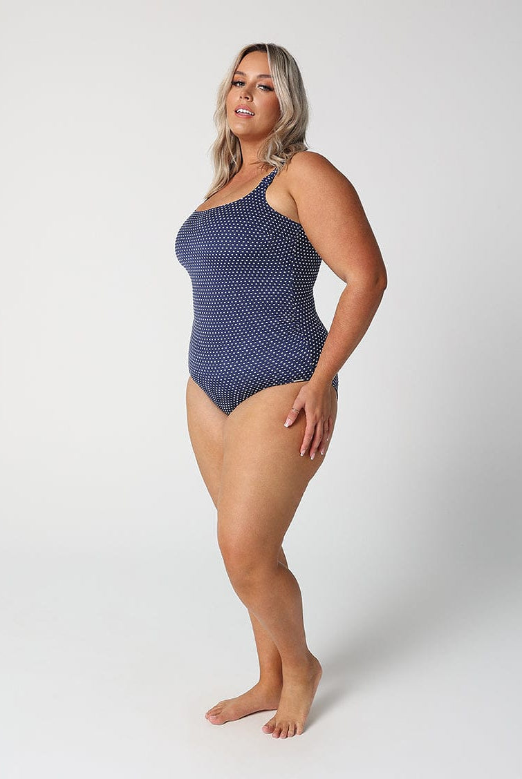 Woman wearing a blue polka dot swimsuit on a white background