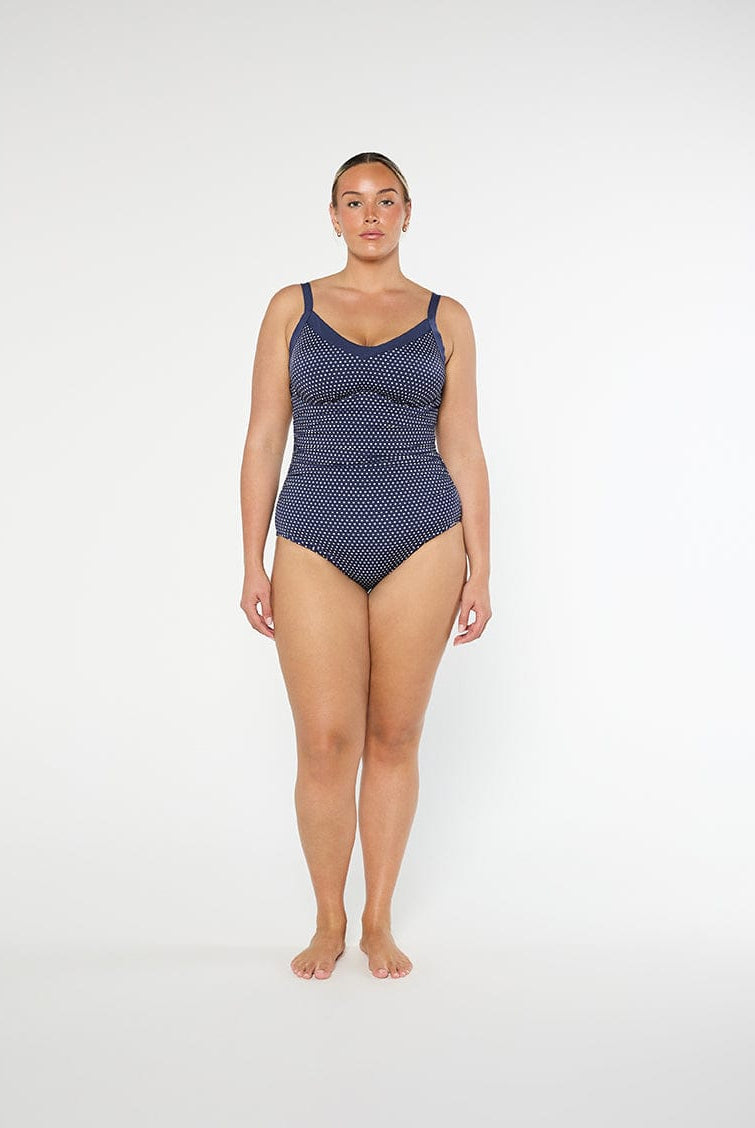 Woman wearing a blue patterned swimsuit on a white background