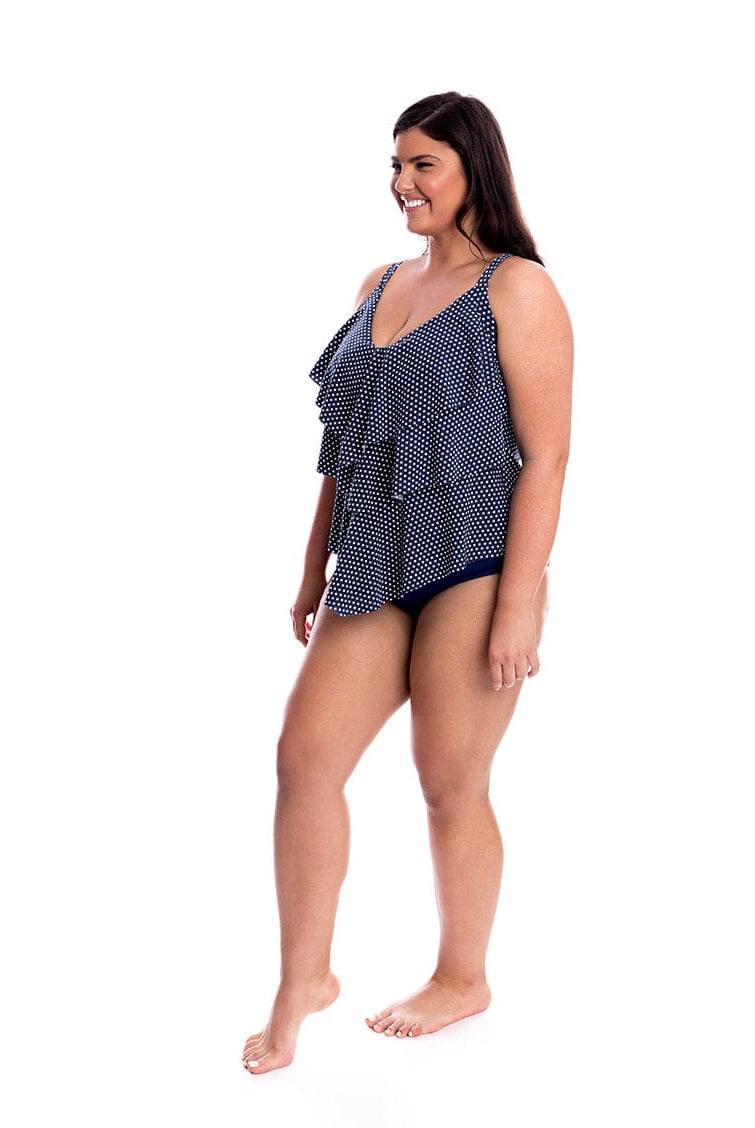 Woman wearing a navy patterned swimsuit on a white background