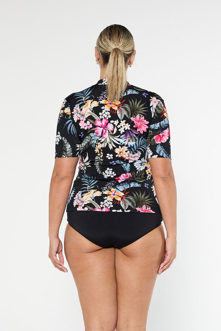 Blonde model shows the back of chlorine resistant floral short sleeve rash vest