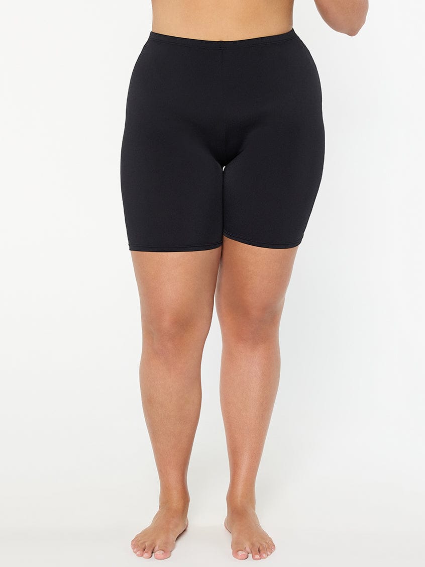 Person wearing black shorts on a white background