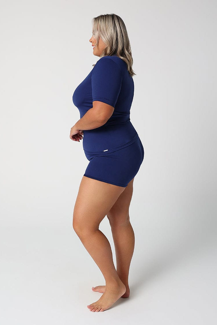 Woman wearing a navy blue outfit on a white background