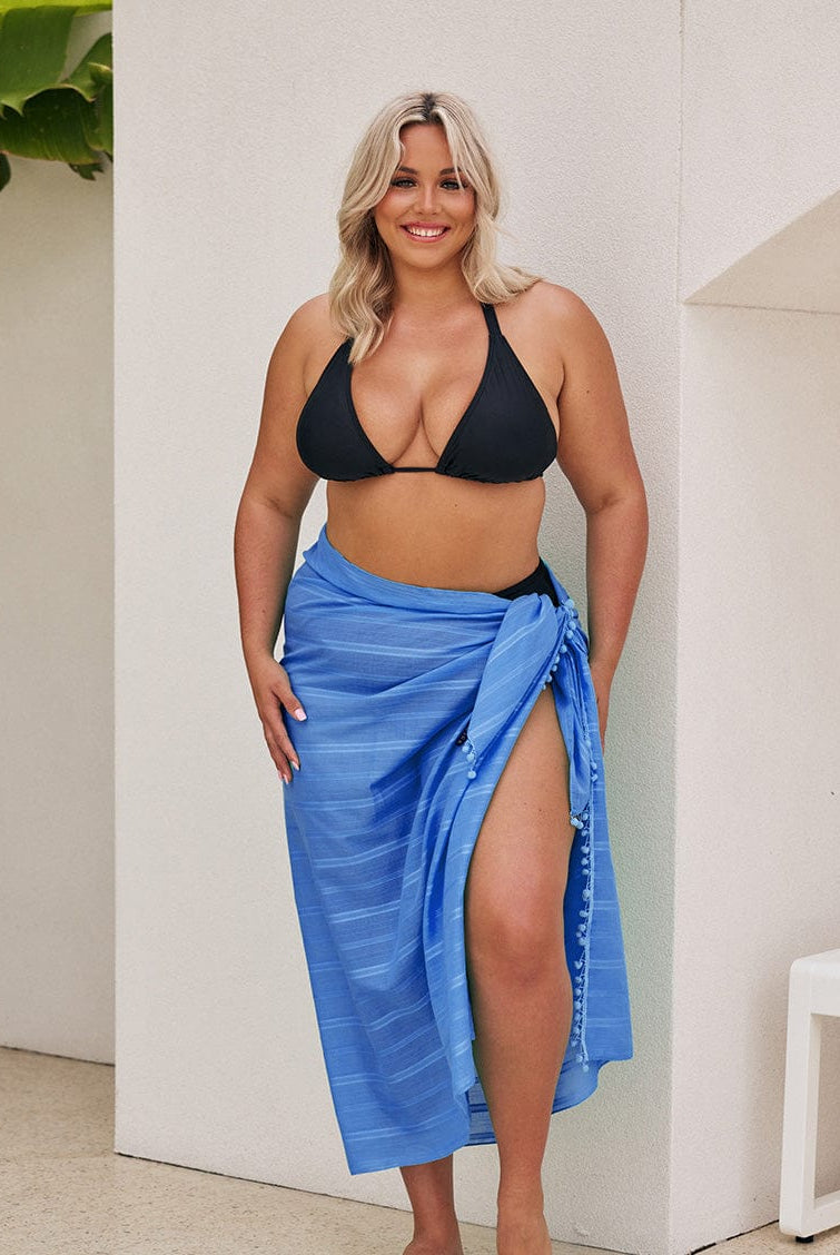 Blonde model wearing a long cotton sarong coverup with pom poms