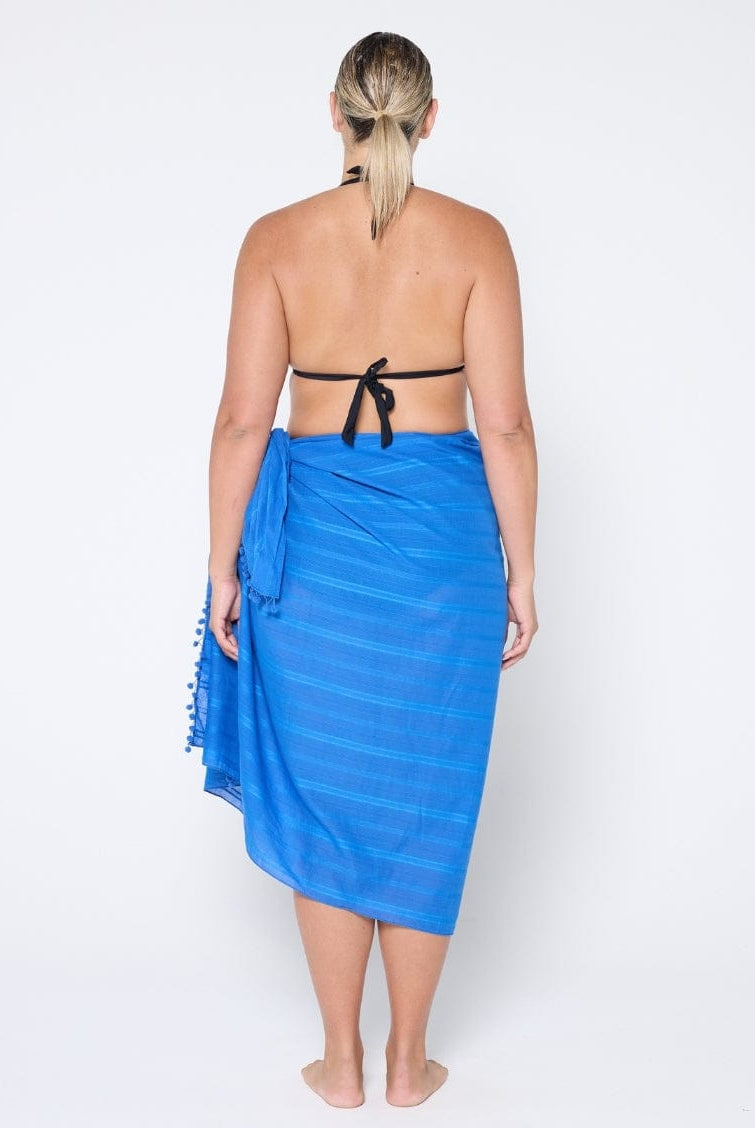 Person wearing a blue sarong on a white background