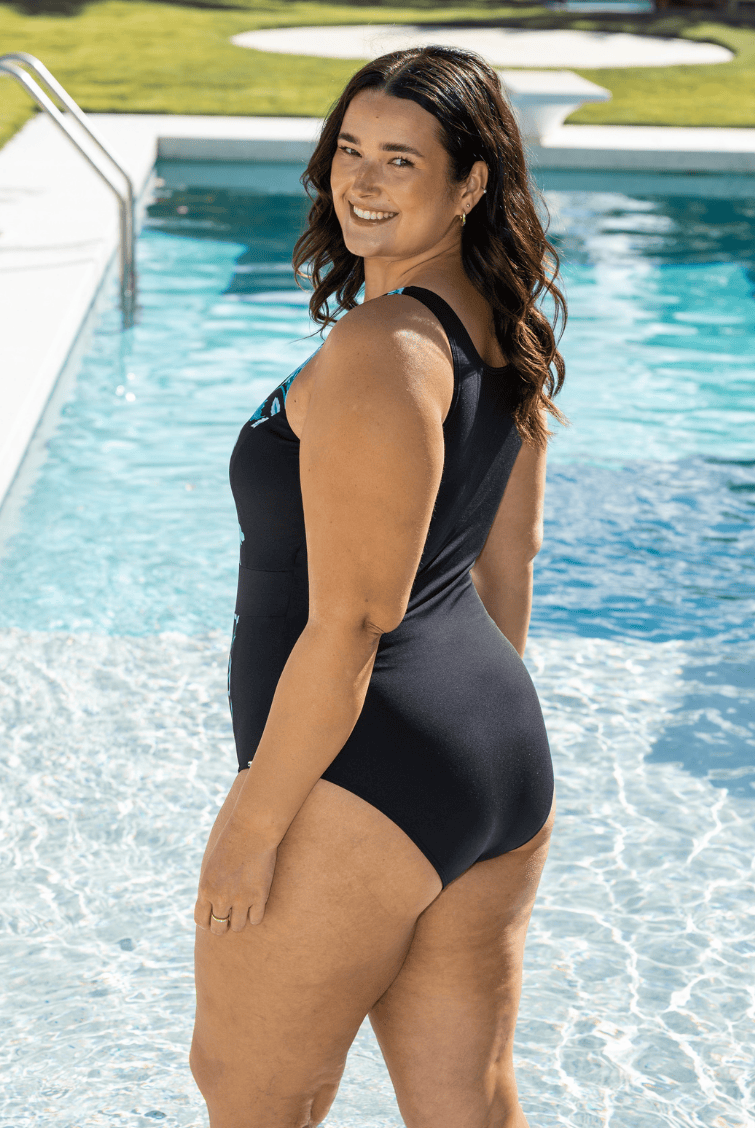 Woman in pool wearing a chlorine resistant zip front one piece with high back.