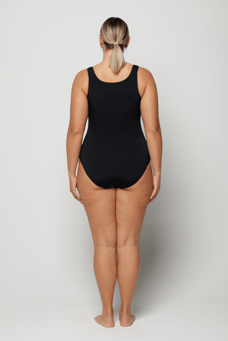 Person wearing a black swimsuit against a white background