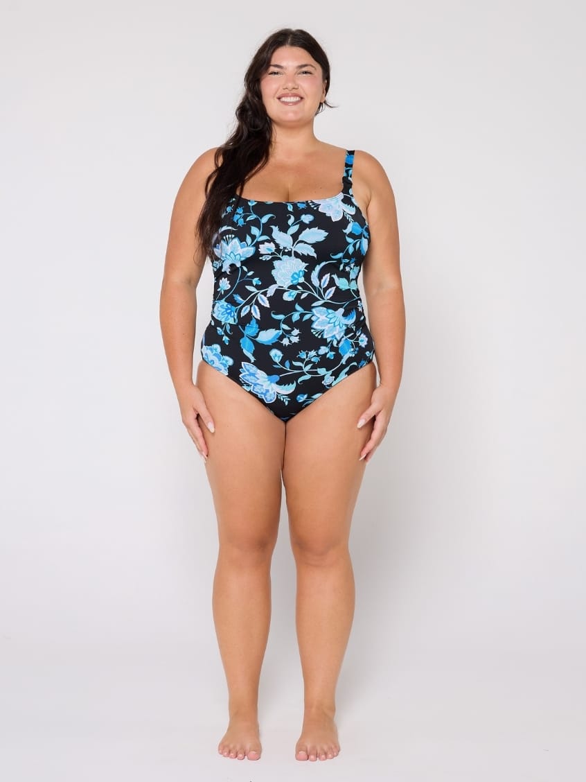 Woman wearing a blue floral swimsuit on a white background